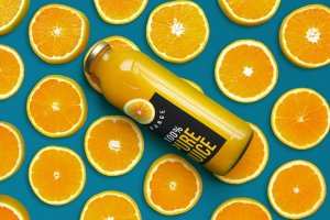 鲜橙果肉背景橙汁瓶包装设计样机 Orange Juice Bottle Mockup